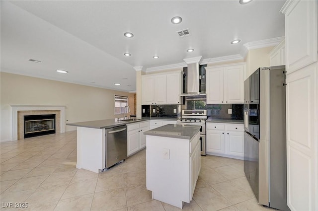 9772 Galahad Point Ct, Las Vegas, NV 89147 - kitchen with appliances with stainless steel finishes, wall chimney exhaust hood, a sink, a peninsula, and backsplash