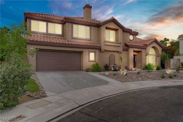 7621 Hackensack Ct, Las Vegas, NV 89128 - mediterranean / spanish house with a chimney, concrete driveway, an attached garage, stucco siding, and a tiled roof