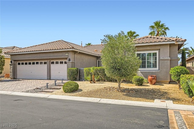 1314 Doggett Ave, Las Vegas, NV 89123 - view of front of property with a tile roof, decorative driveway, a garage, and stucco siding