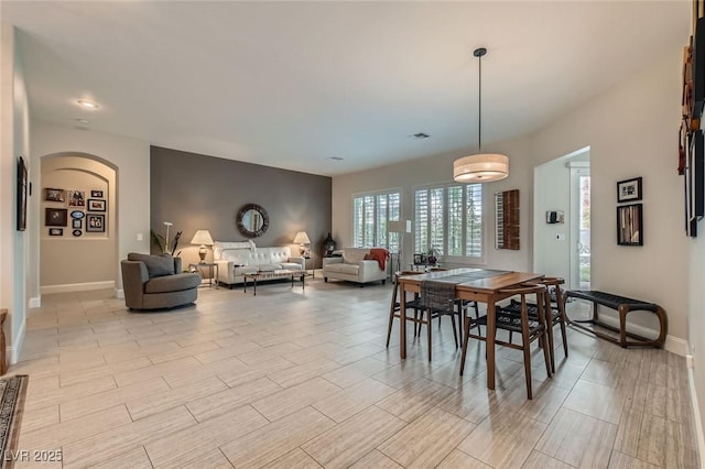 1314 Doggett Ave, Las Vegas, NV 89123 - dining room featuring baseboards, arched walkways, and light wood-style floors