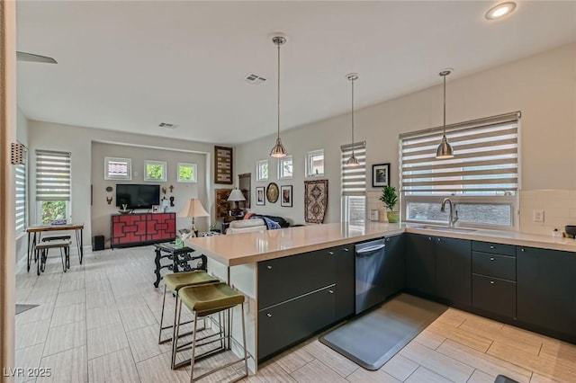 1314 Doggett Ave, Las Vegas, NV 89123 - kitchen with a sink, stainless steel dishwasher, open floor plan, a peninsula, and light countertops