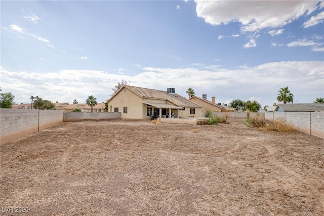 4878 Califa Dr, Las Vegas, NV 89122 - rear view of house with stucco siding, a fenced backyard, a tiled roof, and a patio