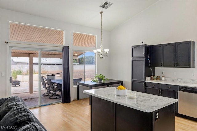 4878 Califa Dr, Las Vegas, NV 89122 - kitchen featuring stainless steel dishwasher, a chandelier, a kitchen island, light wood-style flooring, and vaulted ceiling