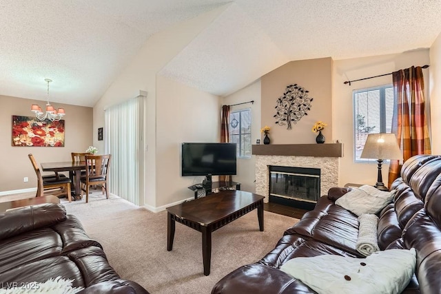 605 Devonhall St Unit 201, Las Vegas, NV 89145 - carpeted living area with a chandelier, vaulted ceiling, a textured ceiling, baseboards, and a fireplace