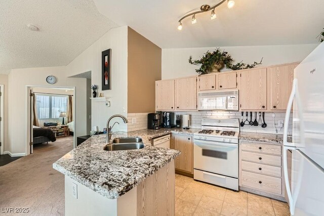 605 Devonhall St Unit 201, Las Vegas, NV 89145 - kitchen featuring white appliances, a sink, a peninsula, light brown cabinetry, and vaulted ceiling