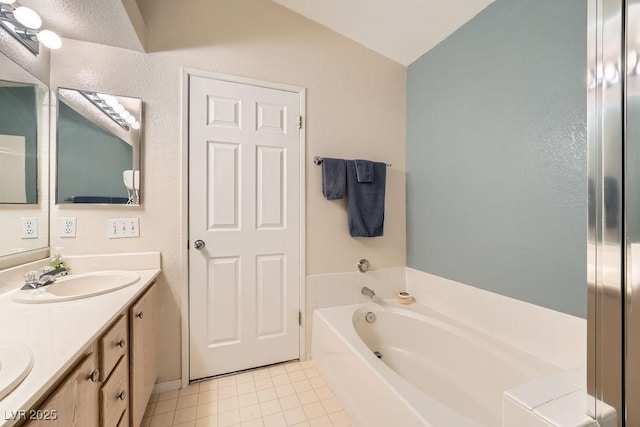 605 Devonhall St Unit 201, Las Vegas, NV 89145 - bathroom featuring a garden tub, double vanity, tile patterned floors, and vaulted ceiling
