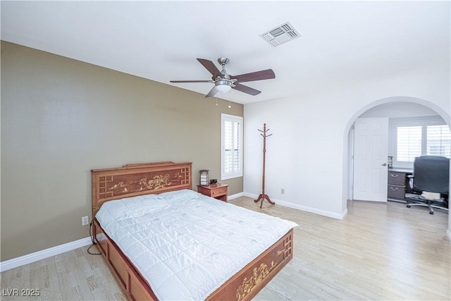9021 Feather River Ct, Las Vegas, NV 89117 - bedroom featuring multiple windows, light wood finished floors, arched walkways, and a desk