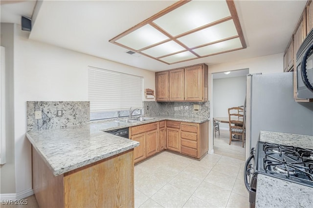 9021 Feather River Ct, Las Vegas, NV 89117 - kitchen featuring tasteful backsplash, a peninsula, range with gas stovetop, and light stone counters
