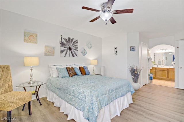 698 S Racetrack Rd Unit 1714, Henderson, NV 89015 - bedroom featuring light wood-style flooring, arched walkways, ensuite bath, and baseboards