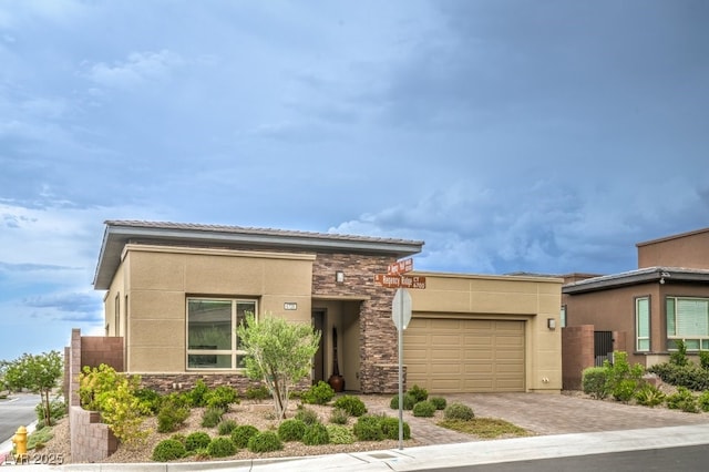 6728 Regency Ridge Ct, Las Vegas, NV 89148 - view of front of property with an attached garage, stone siding, stucco siding, and decorative driveway