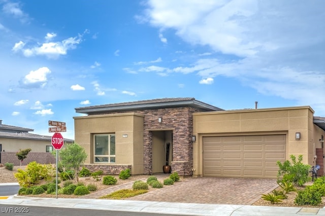 6728 Regency Ridge Ct, Las Vegas, NV 89148 - view of front of home with stone siding, stucco siding, an attached garage, and decorative driveway