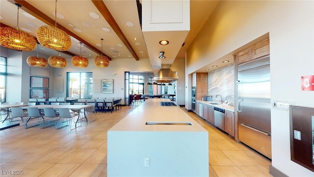 6728 Regency Ridge Ct, Las Vegas, NV 89148 - kitchen with stainless steel appliances, light tile patterned flooring, a sink, a center island with sink, and decorative light fixtures