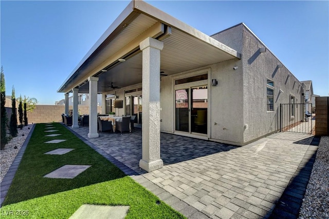 7208 Grace Estate Ave, Las Vegas, NV 89113 - rear view of house with a ceiling fan, a fenced backyard, stucco siding, an outdoor hangout area, and a patio area