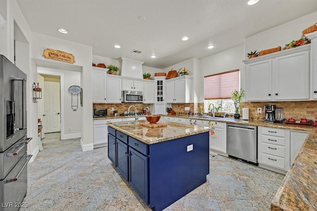 7408 Via Fiorentino St, Las Vegas, NV 89131 - kitchen featuring stainless steel appliances, white cabinets, blue cabinetry, recessed lighting, and light stone counters
