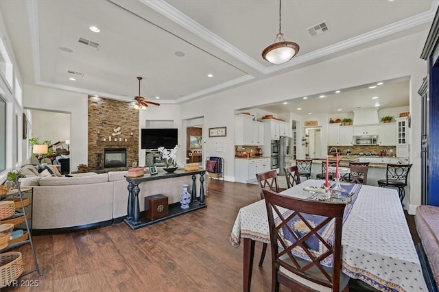 7408 Via Fiorentino St, Las Vegas, NV 89131 - dining room with ceiling fan, dark wood finished floors, ornamental molding, a fireplace, and recessed lighting