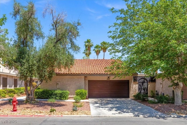 2480 Domingo St, Las Vegas, NV 89121 - view of front of home featuring stucco siding, a garage, driveway, and a tiled roof