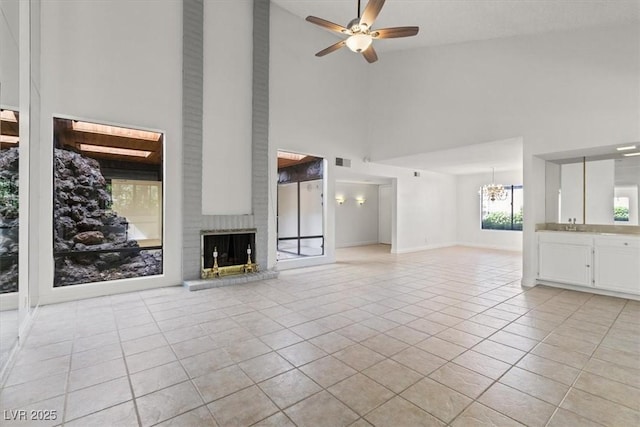 2480 Domingo St, Las Vegas, NV 89121 - unfurnished living room featuring high vaulted ceiling, a brick fireplace, light tile patterned flooring, a chandelier, and a ceiling fan