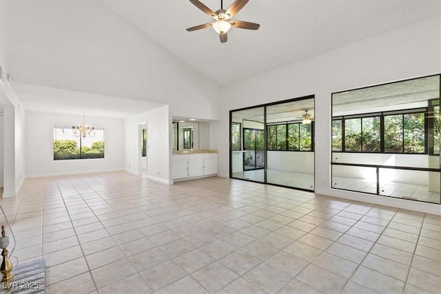 2480 Domingo St, Las Vegas, NV 89121 - empty room featuring a ceiling fan, light tile patterned floors, a chandelier, high vaulted ceiling, and baseboards