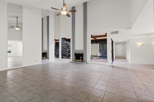 2480 Domingo St, Las Vegas, NV 89121 - unfurnished living room featuring a high ceiling, a brick fireplace, ceiling fan, tile patterned flooring, and baseboards