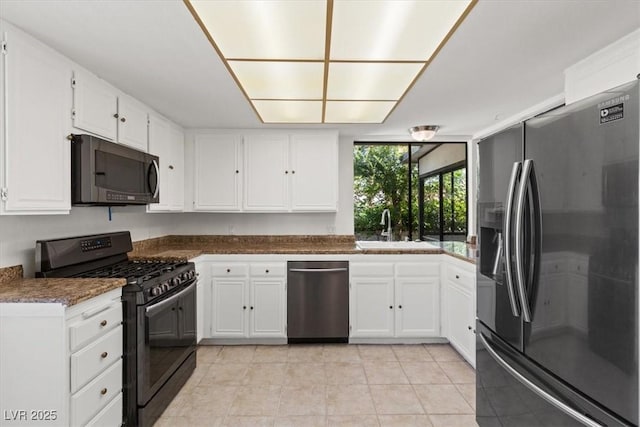 2480 Domingo St, Las Vegas, NV 89121 - kitchen featuring black appliances, a sink, light tile patterned floors, white cabinets, and dark countertops
