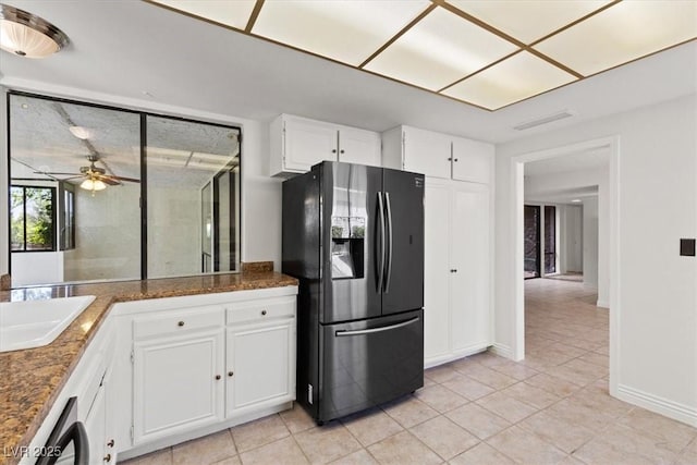 2480 Domingo St, Las Vegas, NV 89121 - kitchen with fridge with ice dispenser, light tile patterned flooring, white cabinets, ceiling fan, and baseboards
