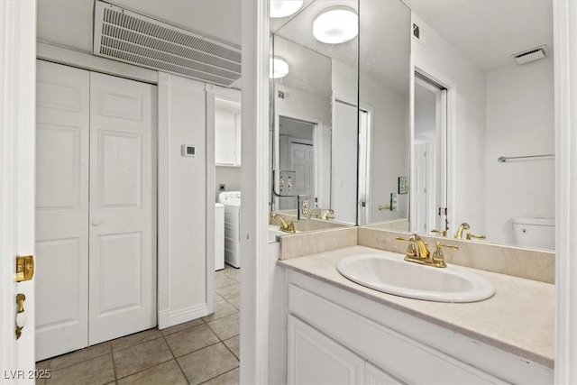 2480 Domingo St, Las Vegas, NV 89121 - bathroom with tile patterned flooring, vanity, a closet, toilet, and washer / dryer