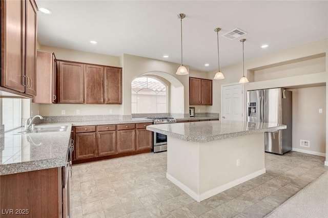 6402 Parrot Ridge Ct, Las Vegas, NV 89139 - kitchen featuring appliances with stainless steel finishes, a sink, brown cabinetry, recessed lighting, and a kitchen island