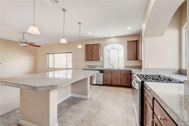 6402 Parrot Ridge Ct, Las Vegas, NV 89139 - kitchen with appliances with stainless steel finishes, a ceiling fan, a kitchen island, light countertops, and hanging light fixtures