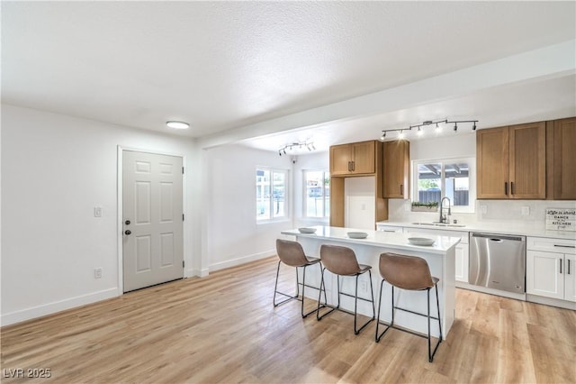 1600 E Mcdonald Ave, North Las Vegas, NV 89030 - kitchen featuring dishwasher, a sink, a breakfast bar, rail lighting, and light countertops