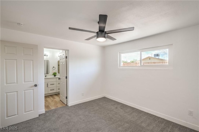 1600 E Mcdonald Ave, North Las Vegas, NV 89030 - unfurnished bedroom featuring light carpet, baseboards, ceiling fan, and connected bathroom