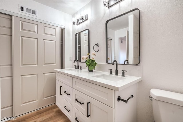 1600 E Mcdonald Ave, North Las Vegas, NV 89030 - bathroom with double vanity, wood finished floors, and toilet
