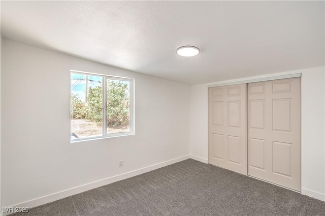 1600 E Mcdonald Ave, North Las Vegas, NV 89030 - unfurnished bedroom with dark colored carpet, baseboards, and a closet