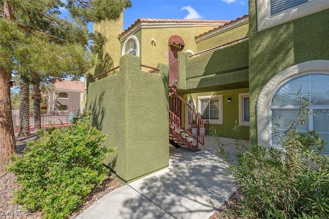 7950 W Flamingo Rd Unit 1003, Las Vegas, NV 89147 - property entrance featuring stucco siding, a tiled roof, a patio, and a chimney