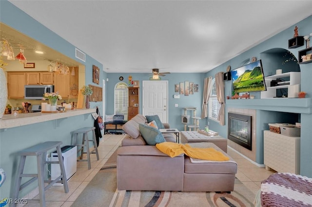7950 W Flamingo Rd Unit 1003, Las Vegas, NV 89147 - living room with light tile patterned flooring, ceiling fan, and a tiled fireplace