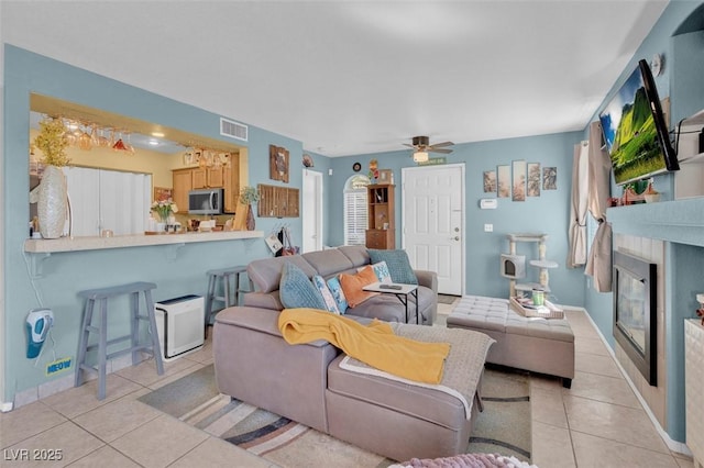 7950 W Flamingo Rd Unit 1003, Las Vegas, NV 89147 - living room with light tile patterned flooring, a glass covered fireplace, and a ceiling fan