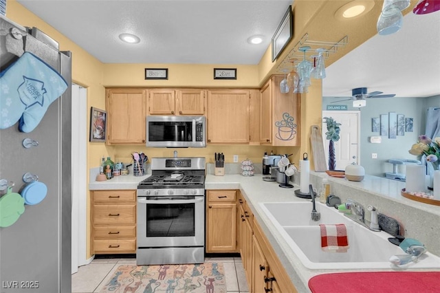 7950 W Flamingo Rd Unit 1003, Las Vegas, NV 89147 - kitchen featuring stainless steel appliances, light brown cabinets, light tile patterned floors, light countertops, and a ceiling fan