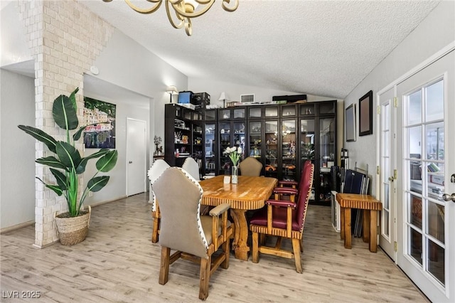 3201 Beacon Shores Cir, Las Vegas, NV 89117 - dining space with vaulted ceiling, a textured ceiling, wood finished floors, and a chandelier