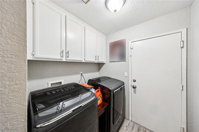 3201 Beacon Shores Cir, Las Vegas, NV 89117 - laundry area featuring washer and dryer, a textured ceiling, cabinet space, light wood finished floors, and a textured wall