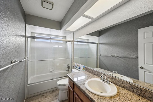 3201 Beacon Shores Cir, Las Vegas, NV 89117 - full bathroom featuring a textured wall, wood finished floors, toilet, vanity, and shower / bath combination with glass door