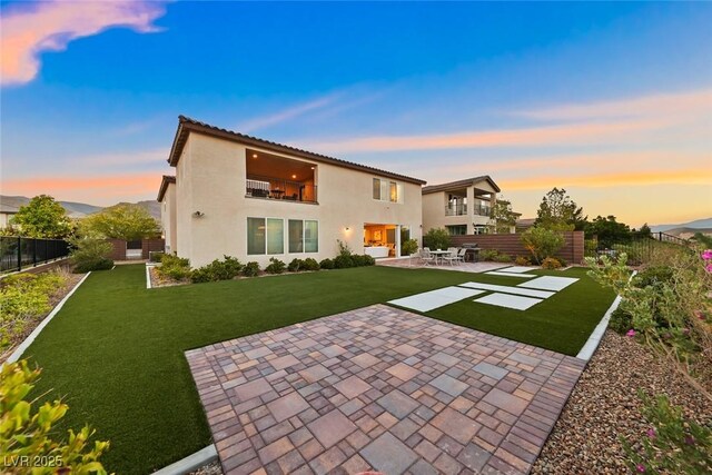 4702 Amazing View St, Las Vegas, NV 89129 - back of property at dusk with a patio area, a balcony, and stucco siding