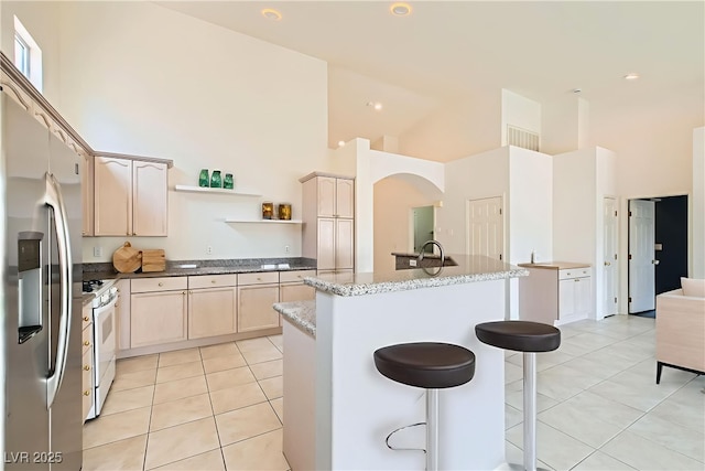 9622 Emeraude Ave, Las Vegas, NV 89147 - kitchen with stainless steel fridge, light tile patterned floors, a towering ceiling, white gas stove, and open shelves