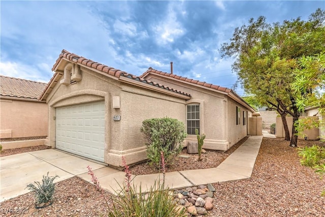 2177 Hidden Ranch Ter, Henderson, NV 89052 - view of home's exterior featuring a garage, a tile roof, driveway, and stucco siding
