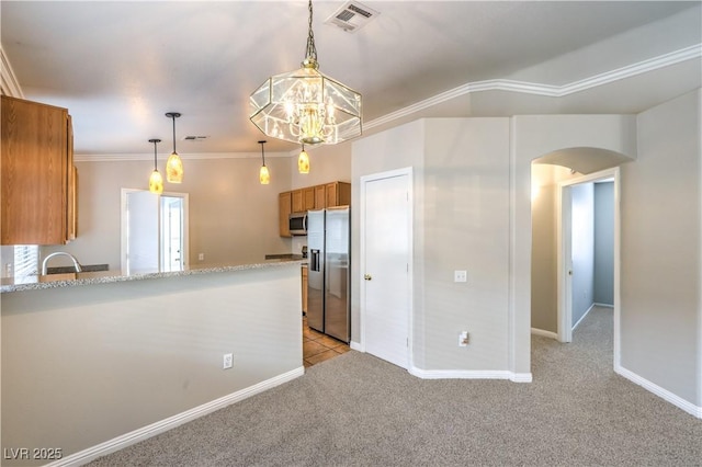 2177 Hidden Ranch Ter, Henderson, NV 89052 - kitchen with appliances with stainless steel finishes, brown cabinets, a sink, light carpet, and arched walkways