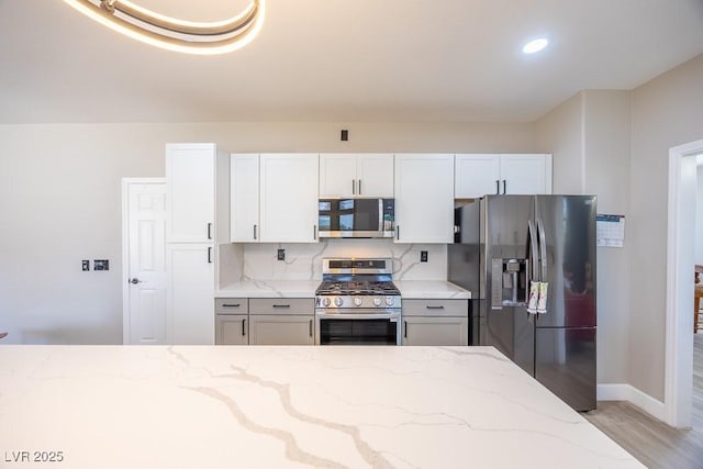 747 Canyon Crest Dr, Las Vegas, NV 89123 - kitchen with appliances with stainless steel finishes, light stone countertops, light wood finished floors, tasteful backsplash, and recessed lighting