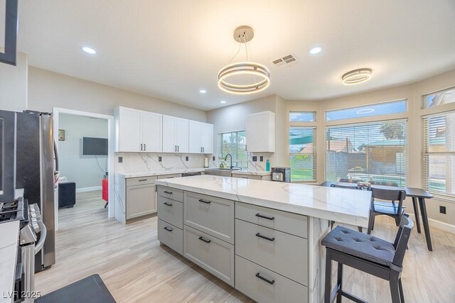 747 Canyon Crest Dr, Las Vegas, NV 89123 - kitchen with a sink, stainless steel range oven, light stone countertops, light wood-style floors, and baseboards