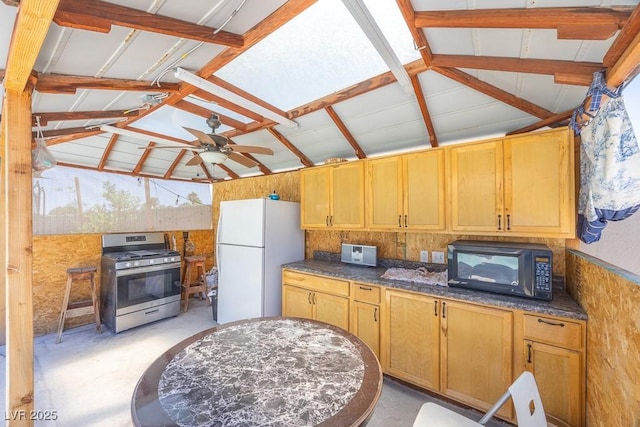 747 Canyon Crest Dr, Las Vegas, NV 89123 - kitchen featuring stainless steel range with gas stovetop, freestanding refrigerator, black microwave, lofted ceiling, and ceiling fan