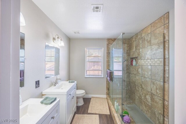 747 Canyon Crest Dr, Las Vegas, NV 89123 - bathroom featuring two vanities, a stall shower, toilet, wood finished floors, and baseboards