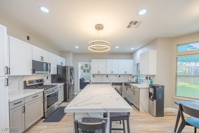 747 Canyon Crest Dr, Las Vegas, NV 89123 - kitchen featuring appliances with stainless steel finishes, a sink, light stone countertops, light wood-style floors, and baseboards