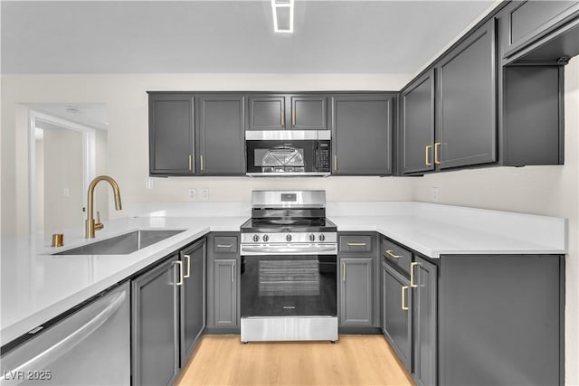 2964 Juniper Hills Blvd Unit 104, Las Vegas, NV 89142 - kitchen with appliances with stainless steel finishes, a sink, light countertops, and light wood-style flooring