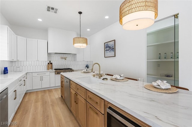 5225 Villa Dante Ave, Las Vegas, NV 89141 - kitchen featuring appliances with stainless steel finishes, white cabinets, light stone countertops, light wood finished floors, and recessed lighting